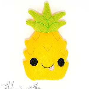 May include: A yellow pineapple plush toy with a green leafy top and a smiling face with a pink tongue sticking out.