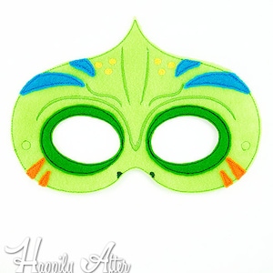 May include: Green felt mask with blue and orange details. The mask has two eye holes and a pointed top.