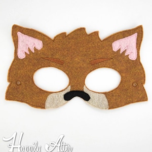 May include: A brown felt fox mask with pink ears and black nose. The mask has eye holes for the wearer.