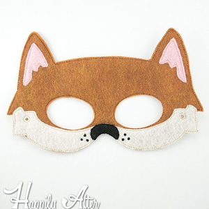 May include: A brown felt fox mask with pink ears, white felt accents, and black felt nose and whiskers.