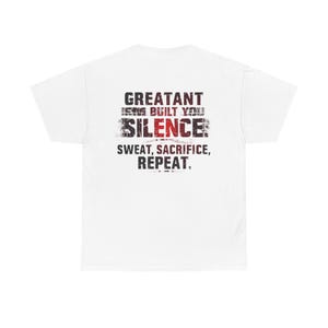 Könnte beinhalten: Weißes T-Shirt mit dem Text "GREATANT ISN'T BUILT YOU SILENCE SWEAT, SACRIFICE, REPEAT" in verblichener schwarzer und roter Schrift. Das T-Shirt hat einen Rundhalsausschnitt und ist aus weichem Material.