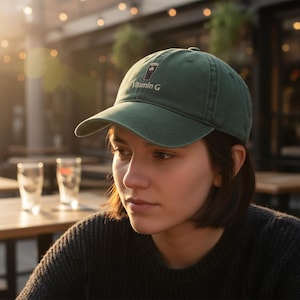 May include: A green baseball cap with the text "Vitamin G" and a graphic of a beer glass with a shamrock. The cap is made of a soft material and has a curved brim. The cap is worn by a person.