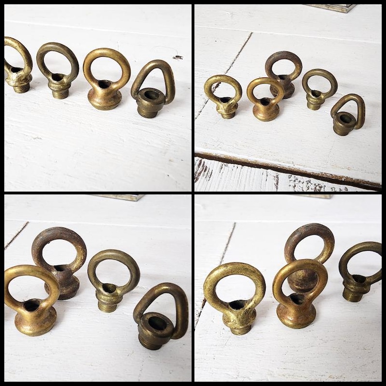 May include: Several antique brass eye bolts with a ring-shaped top and a threaded base are arranged on a white wooden surface. The eye bolts vary slightly in size and finish, showcasing a vintage aesthetic.
