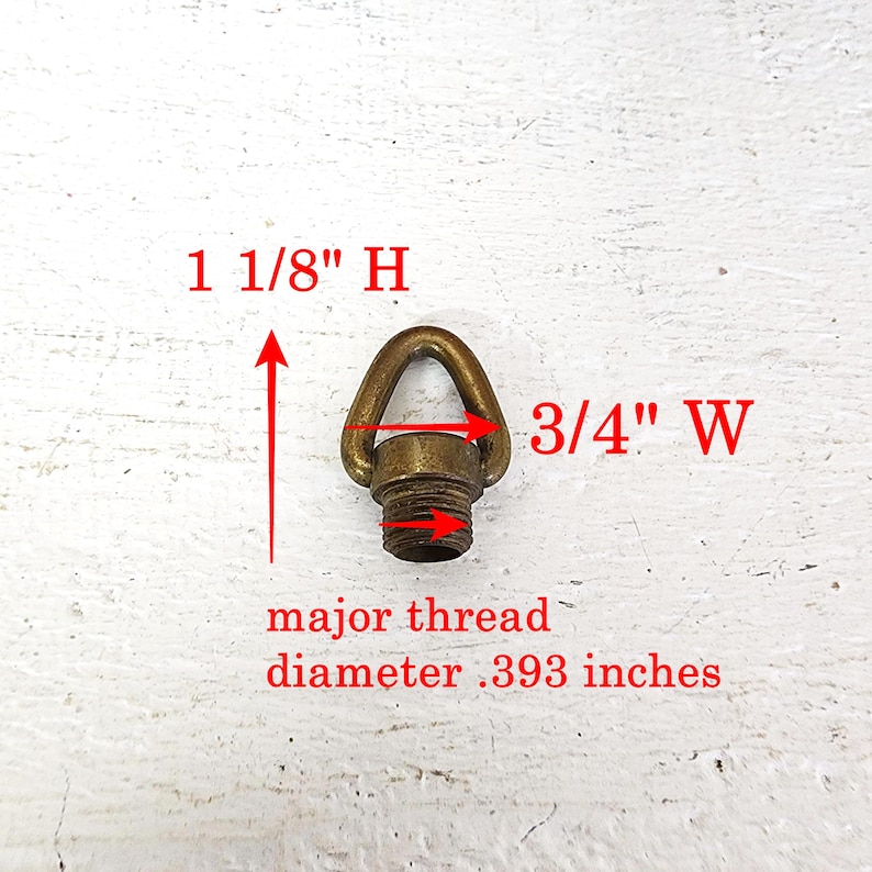 May include: A brass-colored eye bolt with a threaded base. The eye bolt is 1 1/8 inches high and 3/4 inches wide. The major thread diameter is .393 inches. The eye bolt is designed for hanging or securing items.