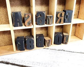 May include: Wooden printing blocks in a drawer with the letters A, S, Y, R, E, F, 1, 8, B, V, O.