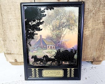 Puede incluir: Obra de arte vintage enmarcada en negro con una silueta de un carruaje tirado por caballos y un paisaje rural. La obra de arte incluye el texto "C. A. McGhee Insurance Agency" en la parte inferior. El fondo muestra una casa y árboles.