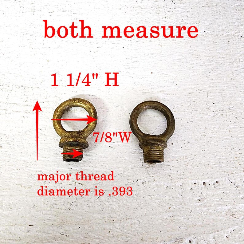May include: Two antique brass eye bolts with threaded bases. The eye bolts are 1 1/4" high and 7/8" wide. The major thread diameter is .393. The text "both measure" is written above the eye bolts in red.