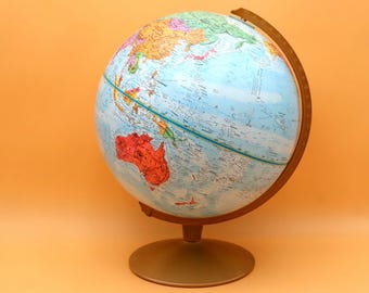 May include: A vintage globe with a blue ocean and colorful continents. The globe is mounted on a gold-colored metal base and has a wooden frame. The globe is a classic educational tool.