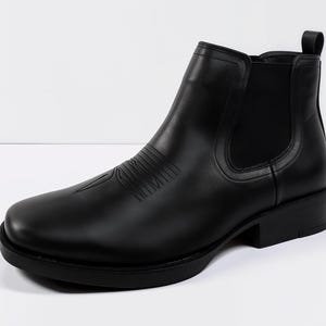 Peut inclure: Bottine cheville en cuir noir avec un bout arrondi et un petit talon bloc. La botte présente un motif décoratif cousu sur l'empeigne et des panneaux latéraux élastiques pour un enfilage facile.