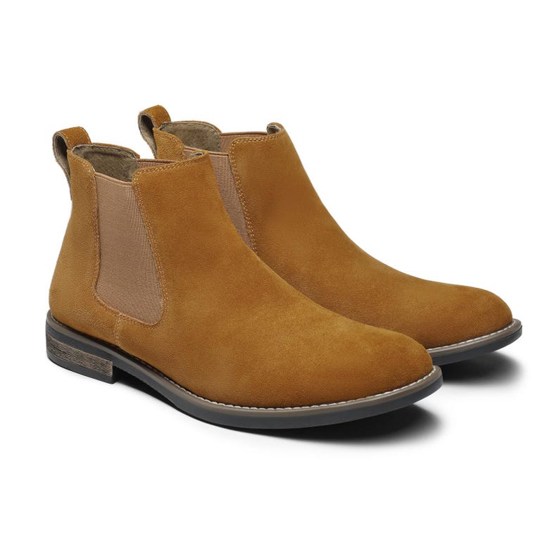 Peut inclure: Paire de bottines Chelsea en daim de couleur beige. Les bottines ont un bout arrondi, des empi&egrave;cements lat&eacute;raux &eacute;lastiques et une tirette &agrave; l'arri&egrave;re. Les semelles sont gris fonc&eacute; avec une bordure gris clair.