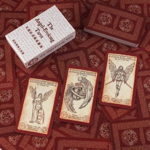 May include: A deck of The Angel-Evoking Tarot cards. The cards are red with detailed illustrations and text. The card box is white with the title in English and Chinese. The cards are scattered on a red background.