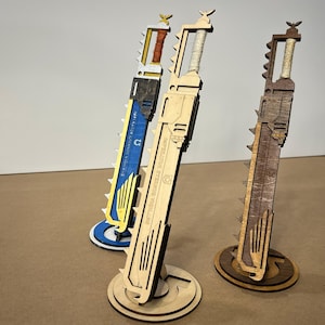 May include: Three wooden decorative swords with intricate designs. The swords have various colors, including natural wood, blue, and brown. Each sword is mounted on a circular base. The text "IMPERATOR STELARIS VIGILANS" is visible on one sword.