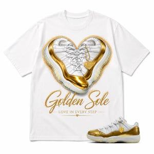 May include: A white short-sleeve t-shirt featuring a graphic of two white and gold sneakers arranged in a heart shape with a gold heart pendant. The text reads Golden Sole LOVE IN EVERY STEP. A matching white and gold sneaker is shown below.
