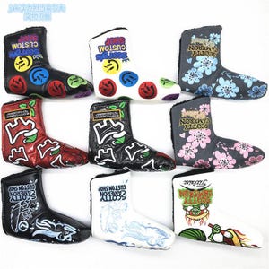 Könnte beinhalten: Neun Golfschlägerhauben in verschiedenen Designs. Die Hauben zeigen Texte wie "Scotty Cameron Custom Shop" und dekorative Elemente wie Blumen, Smiley-Gesichter und grafische Designs. Farben: Schwarz, Weiß, Rot und Grau.