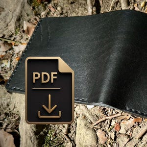 Könnte beinhalten: Ein schwarzes Portemonnaie mit zwei Fächern und sichtbaren dunklen Nähten entlang der Kanten. Das Portemonnaie hat eine glatte, matte Textur und ein gefaltetes Design. Ein Symbol für eine PDF-Datei mit einem Pfeil nach unten ist abgebildet.