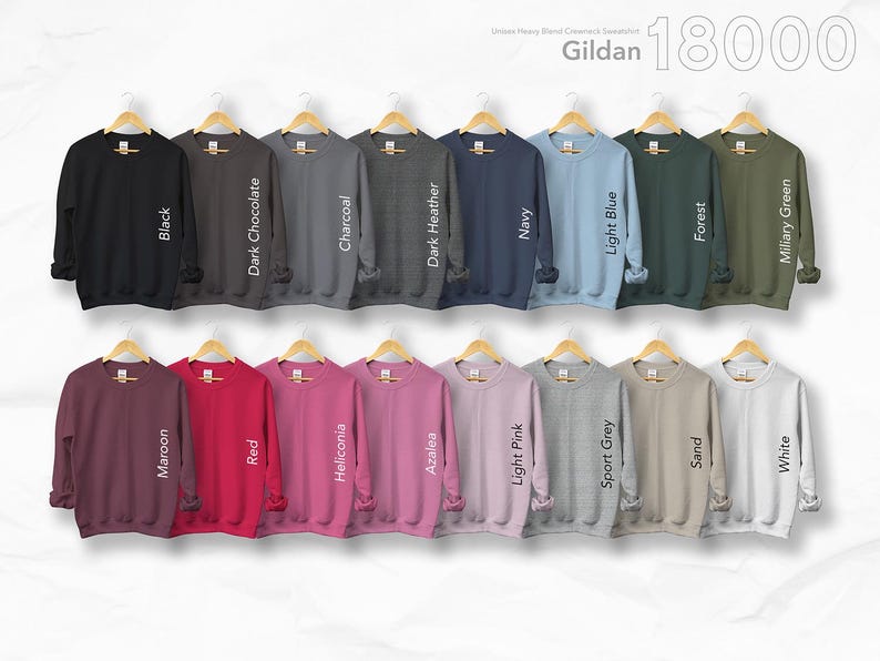 May include: A display of Gildan 18000 crewneck sweatshirts in various colors, including black, navy, and light blue. The sweatshirts are hanging on wooden hangers. The available colors are: Black, Dark Chocolate, Charcoal, Dark Heather, Navy, Light Blue, Forest, Military Green, Maroon, Red, Heliconia, Azalea, Light Pink, Sport Grey, Sand, and White.