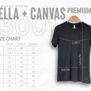 May include: A dark gray Unisex Jersey Short Sleeve Tee from Bella + Canvas, hanging on a wooden hanger. The image includes a size chart with measurements in inches for width, chest, and length.
