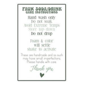 Może przedstawiać: Prostokątny znak z zieloną obw&oacute;dką i białym tłem wyświetla instrukcje dotyczące pielęgnacji produkt&oacute;w typu faux soda lub drink. Tekst zawiera "Myć tylko ręcznie", "Nie moczyć" i "Dziękuję".