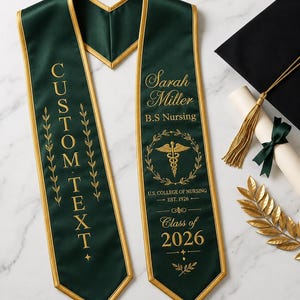 Pode incluir: Uma faixa de formatura verde escuro com borda dourada e texto personalizado. A faixa apresenta o nome "Sarah Miller" e "B.S Nursing", um símbolo de enfermagem e "Turma de 2026". Um chapéu de formatura preto e um diploma também estão presentes.
