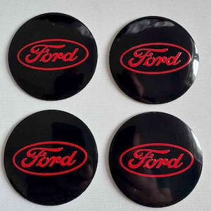 Op de afbeelding: Een witte keramische mok met een zwarte handgreep en de tekst "But First, Coffee" in een handschriftstijl. De mok is ongeveer 10 cm hoog en bevat ongeveer 350 ml vloeistof.