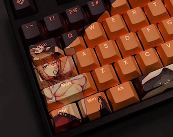 May include: Close-up of a black mechanical keyboard with orange keycaps. Some keycaps feature anime-style illustrations. The keyboard has a standard QWERTY layout with function keys and number keys. The keycaps are backlit.