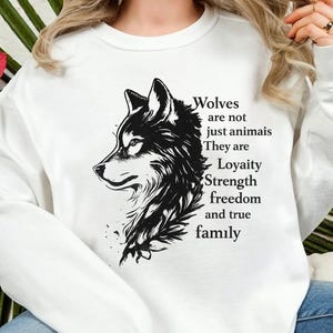 May include: White sweatshirt featuring a black and white wolf illustration with text. The text reads "Wolves are not just animals. They are Loyalty, Strength, freedom and true family."