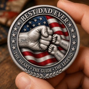 May include: A circular silver-toned commemorative coin featuring a raised fist bump design against a red, white, and blue American flag background. The text reads BEST DAD EVER, THE HEART, THE GUIDE, THE LEGEND, with labels Dad, Noah, and Sophia.