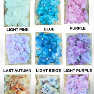 May include: Nine clear plastic bags filled with artificial hydrangea flowers in various colors, including white, turquoise, pink, light pink, blue, purple, last autumn, light beige, and light purple. Each flower has a pearl center.