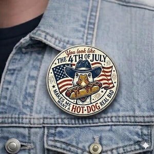 May include: A round pin featuring a cartoon duck wearing a cowboy hat and holding a hot dog. The pin includes the text "You look like the 4th of July" and "Makes me want a hot dog real bad" with American flag imagery.
