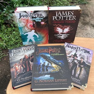 May include: A collection of five hardcover books with the title "James Potter" on the covers. The books feature various illustrations, including a clock, a figure, and a dragon. The author's name, G. Norman Lippert, is also visible.