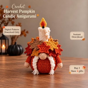 May include: A crochet amigurumi pumpkin gnome featuring a white candle topper with a yellow and orange flame. The gnome is adorned with various autumn-colored leaves in red, orange, and brown. It has white braided hair and a round nose.