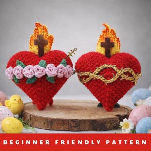 Puede incluir: Dos adornos de corazón rojo de ganchillo, uno con rosas rosas y el otro con una corona de espinas dorada. Cada corazón tiene una cruz de madera y una llama. El texto "BEGINNER FRIENDLY PATTERN" está en la parte inferior.