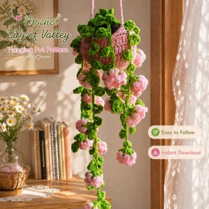 May include: A crocheted hanging plant in a pink pot with green vines and light pink bell-shaped flowers. The text reads Crochet Lily of Valley Hanging Pot Pattern, Easy to Follow, and Instant Download. The plant hangs from a pink cord.