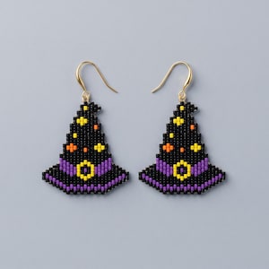 May include: A pair of dangle earrings shaped like witch hats, crafted from small black, purple, yellow, and orange beads. Each hat features a purple band with a yellow buckle and small yellow and orange star-like accents, suspended from gold-tone hooks.