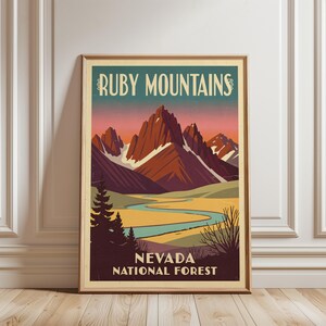 Może przedstawiać: Oprawiony plakat z stylizowaną ilustracją gór Ruby Mountains w Nevadzie. Grafika przedstawia poszarpane, czerwonobrązowe szczyty na tle zachodzącego słońca, wijącą się niebieską rzekę i ciemne sosny. Napis: RUBY MOUNTAINS oraz NEVADA NATIONAL FOREST.