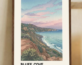 May include: A framed art print featuring a coastal landscape with the text "BLUFF COVE, Palos Verdes Estates, CA." The artwork depicts a cliffside view of the ocean under a pastel sky. The print is in a dark brown wooden frame.