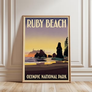 May include: A framed vertical poster featuring a stylized illustration of Ruby Beach in Olympic National Park. The artwork displays a sunset over the ocean with dark rock formations, a sandy shoreline, and trees. The text reads RUBY BEACH and OLYMPIC NATIONAL PARK.