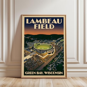 Puede incluir: Un póster vertical enmarcado que presenta una ilustración aérea del Lambeau Field en Green Bay, Wisconsin. La obra muestra el estadio iluminado de noche bajo un cielo crepuscular, con los aparcamientos y zonas residenciales visibles.