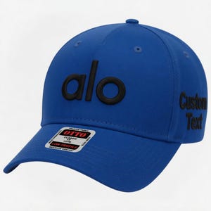 Pu&ograve; includere: Un cappellino da baseball blu reale con la scritta "alo" in nero ricamata sul davanti. Il lato destro del cappellino presenta il testo "Custom Text" in nero. Una piccola etichetta "OTTO" &egrave; visibile sulla visiera.