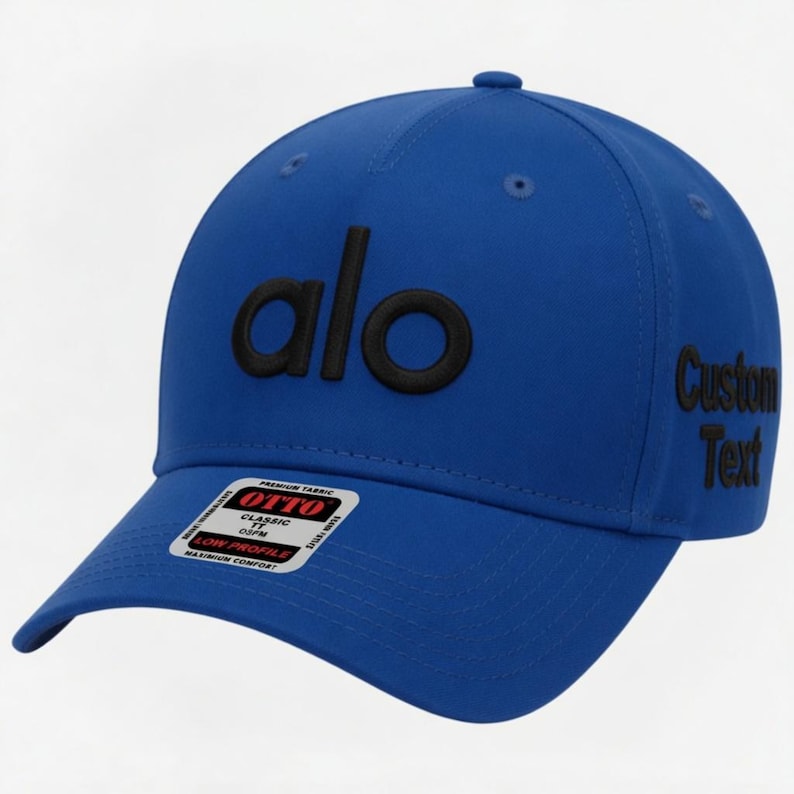 Pu&ograve; includere: Un cappellino da baseball blu reale con la scritta "alo" in nero ricamata sul davanti. Il lato destro del cappellino presenta il testo "Custom Text" in nero. Una piccola etichetta "OTTO" &egrave; visibile sulla visiera.
