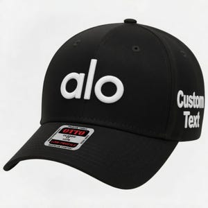 Pu&ograve; includere: Cappellino da baseball nero con la scritta bianca "alo" sul davanti e "Custom Text" sul lato. Il cappellino ha una visiera curva e una piccola etichetta sulla visiera.