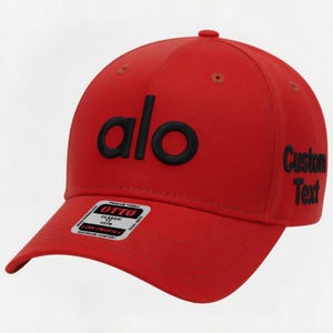 Pu&ograve; includere: Cappellino da baseball rosso con la scritta "alo" in lettere nere sul davanti. Il testo "Custom Text" &egrave; sul lato. Una piccola etichetta bianca &egrave; sulla tesa.