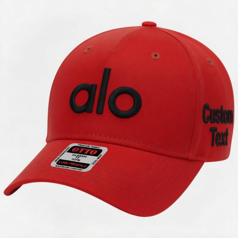 Pu&ograve; includere: Cappellino da baseball rosso con la scritta "alo" in lettere nere sul davanti. Il testo "Custom Text" &egrave; sul lato. Una piccola etichetta bianca &egrave; sulla tesa.