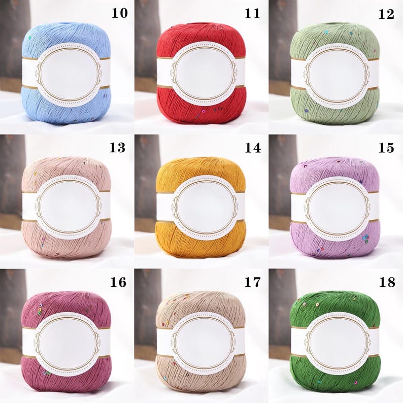 Puede incluir: Una colecci&oacute;n de madejas de hilo coloridas, cada una con una etiqueta blanca. Los colores del hilo incluyen azul claro, rojo, verde, rosa, amarillo, morado, burdeos, beige y verde oscuro. El hilo est&aacute; envuelto con una banda blanca, y algunas madejas tienen purpurina.