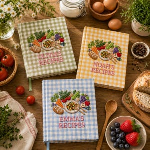 May include: Three recipe journals with embroidered food designs and the names "Olivia's Recipes", "Noah's Recipes", and "Emma's Recipes" on the covers. The journals have gingham patterns in green, yellow, and blue. The image includes fresh produce and cooking utensils.