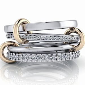 May include: A multi-band ring with a gold band and three silver bands, each set with a row of small diamonds.