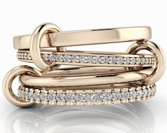 May include: A rose gold ring set with a band of small diamonds. The ring is made of multiple bands that are intertwined and connected by a knot.