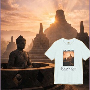Może przedstawiać: Jasnoniebieska koszulka z grafiką świątyni Borobudur w Jawie, Indonezja. Tekst "I've been here" znajduje się nad obrazem, a "Borobudur JAVA, INDONESIA" pod nim. Tło przedstawia świątynię o zachodzie słońca.