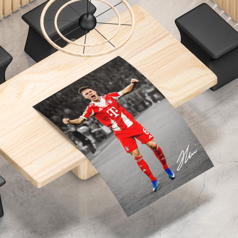 May include: A rectangular poster featuring a soccer player in a red and white jersey with the number 6, celebrating on a field. The background is in black and white, while the player is in color. A white signature is visible in the bottom right corner.