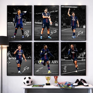 May include: A set of six framed black and white posters featuring professional football players in dark blue kits with red accents on a pitch. Each poster displays a unique player in action and includes a white handwritten signature at the bottom.
